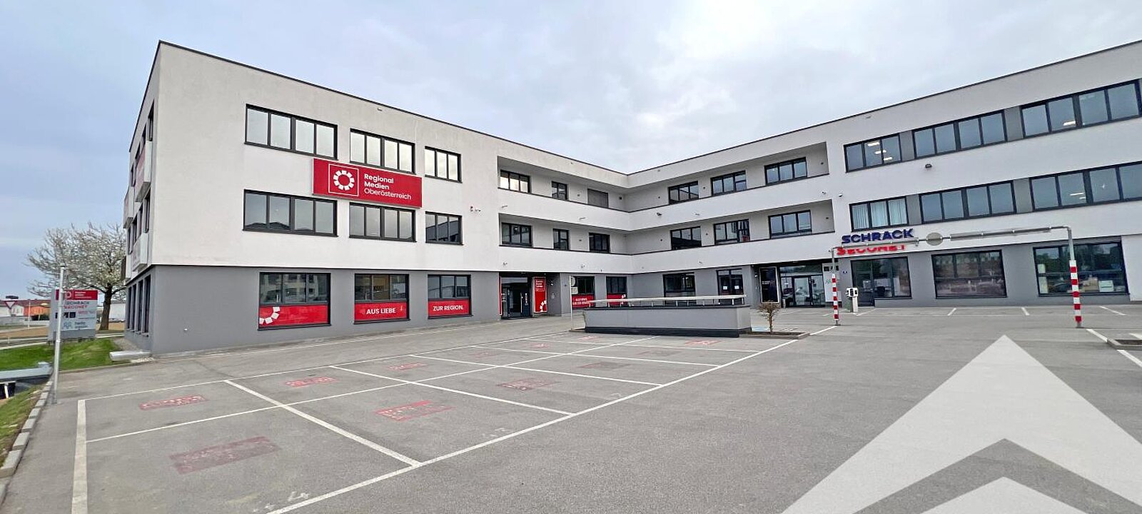 Gebäudeansicht mit Parkplätzen Gebäudeansicht mit Parkplätzen