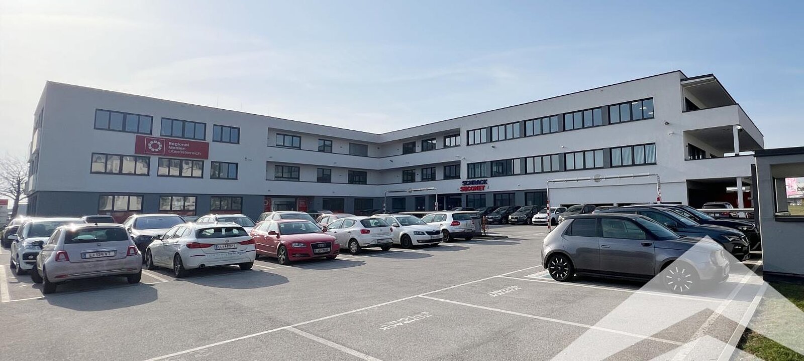 Gebäudeansicht mit Parkplätzen